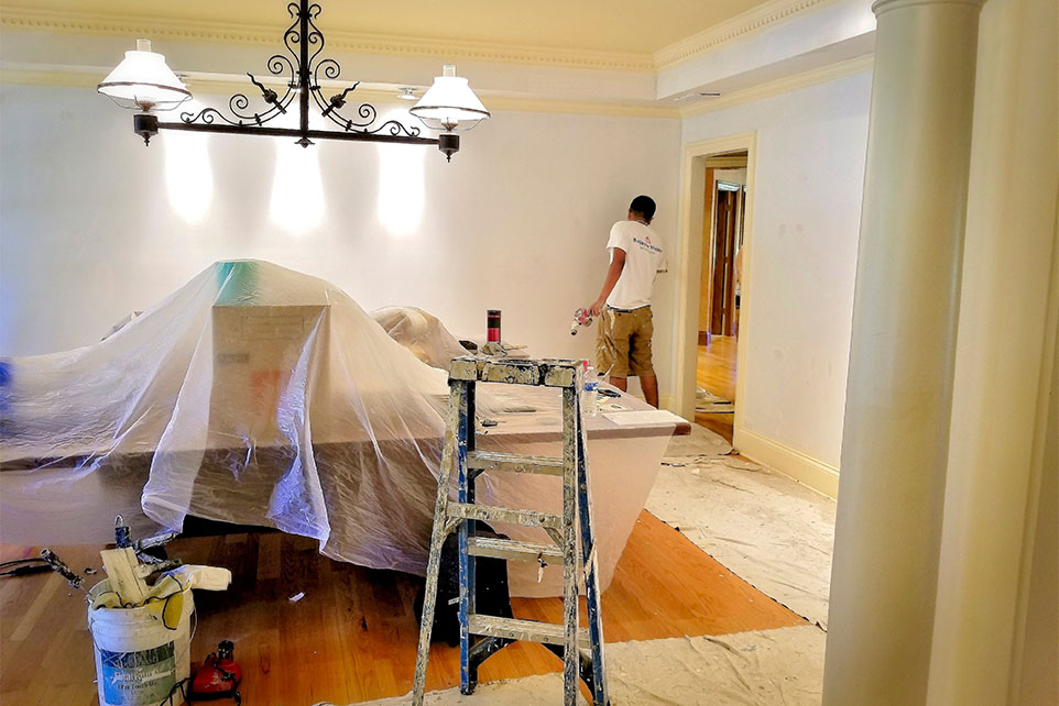 Interior painting contractor working on walls during residential renovation project.