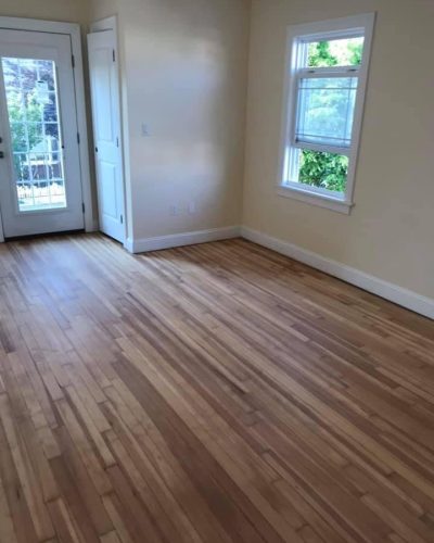 A room featuring hardwood floors and a closed door, creating a warm and inviting atmosphere.