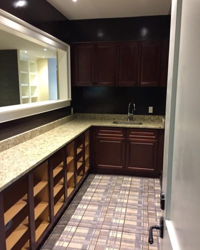 A modern kitchen featuring wooden cabinets and sleek countertops, showcasing a clean and organized cooking space.