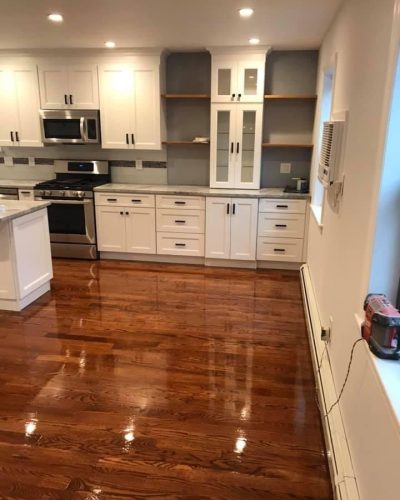 A modern kitchen featuring hardwood floors and sleek white cabinets, creating a bright and inviting atmosphere.